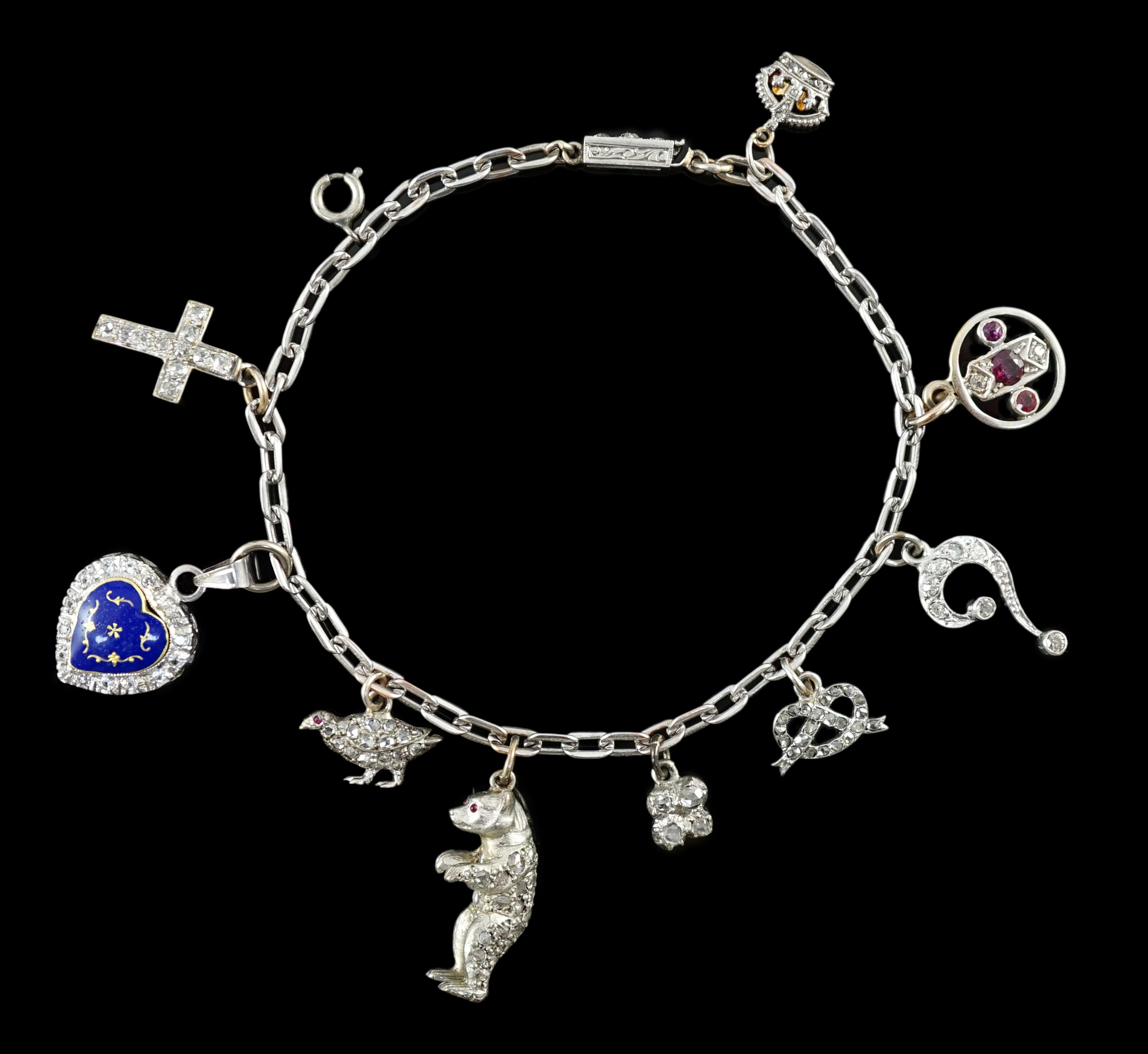 A 9ct white gold charm bracelet, with French platinum and diamond set clasp and hung with nine assorted charms, eight set with diamonds